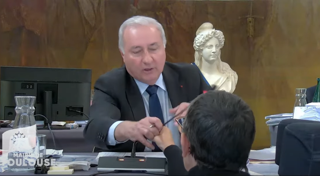 Capture d'écran d'un extrait du Conseil municipal du 26 septembre 2025 de Toulouse, où l'on voit une élue handicapée venue à la tribune pour demander la parole après un énième épisode de censure, et qui se voit arracher le micro des mains après avoir tenté de prendre le micro pour répondre au maire.
